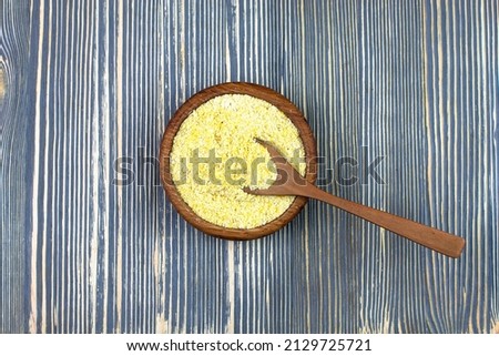 Ground cornmeal in a wooden bowl.