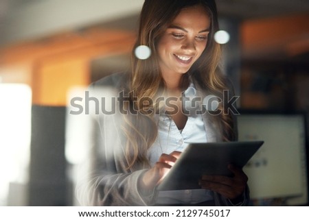 Working hard no matter the time. Shot of a young attractive businesswoman working late at night in a modern office. Royalty-Free Stock Photo #2129745017