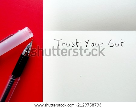 Pen on notebook with handwritten text TRUST YOUR GUT refers to trusting feelings of intuition,Following  instinct, can be valuable tool in some circumstances Royalty-Free Stock Photo #2129758793
