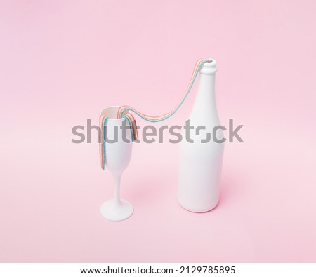 White champagne glass and bottle with colorful rainbow chewing gum how they spill into each other. Pink pastel ackground.