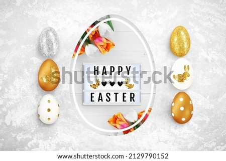 Shining Easter eggs on a concrete background. Lightbox and flowers in egg shaped hole. Text frame of the lightbox with the inscription Happy Easter, hearts, bunnies. Top view, close up, copy space