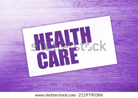 Health Care words on card on wooden table. medicine concept