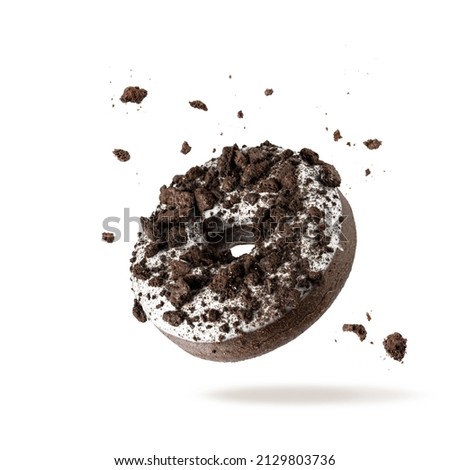 White chocolate glazed donut with dark cookies crumbs and creme filled closeup flying. Sweet doughnut falling isolated on white background Royalty-Free Stock Photo #2129803736