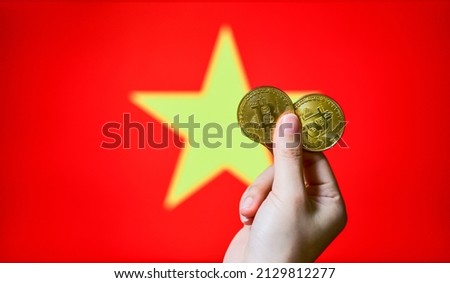 Hold a physical Bitcoin (the new virtual currency) as well as the Vietnamese flag. Investor concept map for Vietnam's cryptocurrencies and blockchain technologies