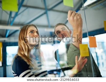 Keeping business evolving with a creative brainstorming session. Shot of colleagues having a brainstorming session with sticky notes at work. Royalty-Free Stock Photo #2129816033