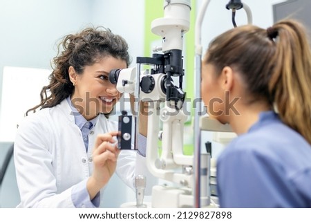 Eye doctor with female patient during an examination in modern clinic. Ophthalmologist is using special medical equipment for eye health saving and improving. Royalty-Free Stock Photo #2129827898