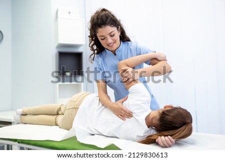 Physiotherapist treatment patient. Holding patient's hand, shoulder joint treatment. Physical Doctor consulting with patient About Shoulder muscule pain problems Physical therapy diagnosing concept Royalty-Free Stock Photo #2129830613