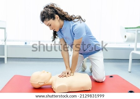 CPR class with instructors talking and demonstrating firt aid, compressions ans reanimation procedure. Cpr dummy Royalty-Free Stock Photo #2129831999