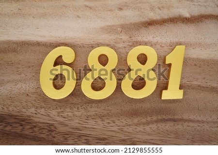 Wooden  numerals 6881 painted in gold on a dark brown and white patterned plank background.