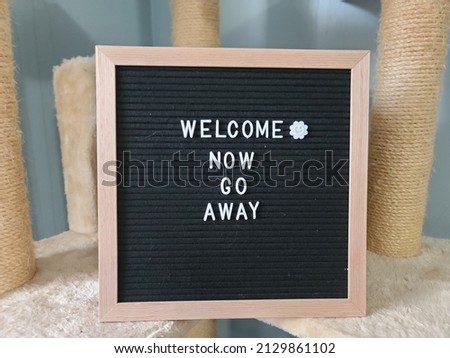A sign saying welcome now go away. The felt sign has removable letters than can be moved around to make whatever words or saying one wants. 