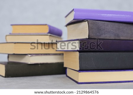 Stack of purple books on gray background