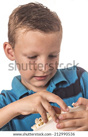 boy in blue shirt in studio eating popcorn