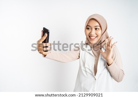 woman in hijab holding a smart phone for selfie