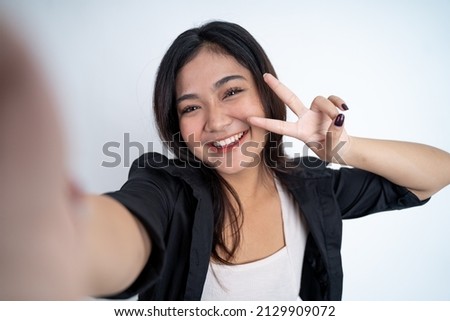 young woman selfie using mobile phone camera with v sign