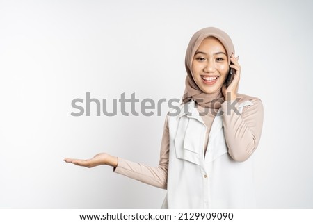 sian woman making a call using a cell phone and presenting copy space
