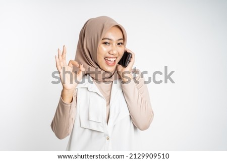 woman making a call using a cell phone and showing thumb up