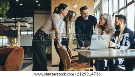 Businesspeople having a discussion while collaborating on a new project in an office. Group of diverse businesspeople having a meeting together in a modern workspace. Royalty-Free Stock Photo #2129914736