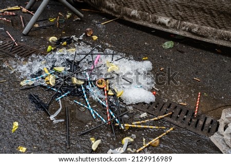 night club rubbish plastic straws lemon and lime wedges and ice cubes left on the floor outside after the night before Royalty-Free Stock Photo #2129916989
