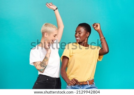 Grab your girl and get grooving. Studio shot of two young women dancing together against a turquoise background. Royalty-Free Stock Photo #2129942804