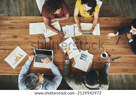 Birds-eye view of business. High angle shot of a team of businesspeople meeting around the boardroom table in the office. Royalty-Free Stock Photo #2129942972