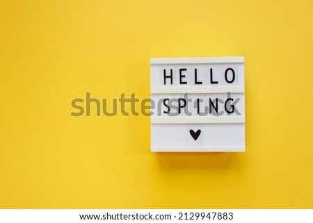 lightbox with text Hello spring on color background. Top view Flat lay Springtime concept