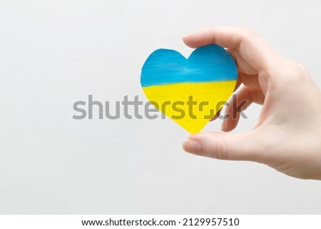 The concept of ending the war in Ukraine. heart in the colors of the flag of Ukraine in female hands