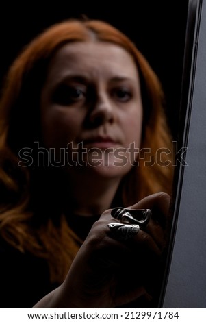 Red hair woman painting. Portrait of an artist with shadows. Abstract shot.