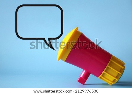 Megaphone, loudhailer on blue background with blank speech bubble. Copy space for text.