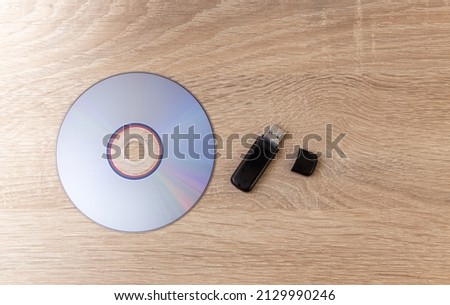 CD with USB stick on wooden table