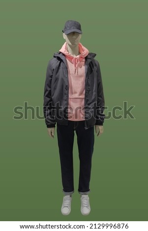 Full length image of a male display mannequin wearing fashionable clothes isolated on a green background