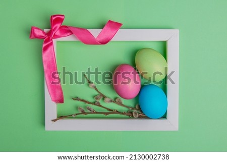 on a green background bow and easter eggs in a white frame