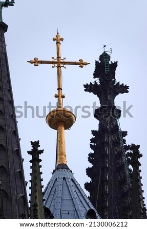 Golden cross on the roof of the Cologne Cathedral against the sky