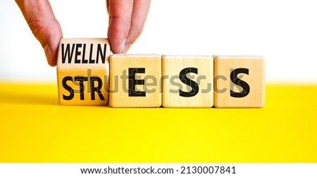 Wellness or stress symbol. Doctor turns the wooden cube and changes the word Stress to Wellness. Beautiful white background. Medical, psychological, wellness or stress concept. Copy space.