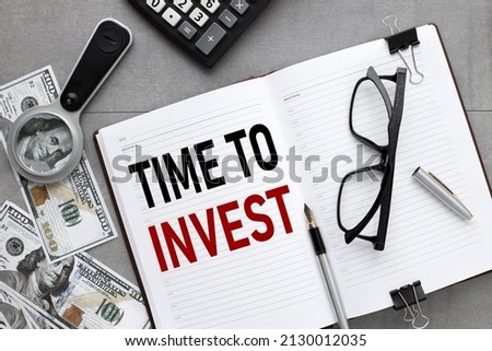 time to invest. open notepad with text. banknotes and calculator. view from above. business concept. brown background