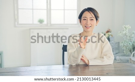 Young Asian woman talking in the room. Interview recording. Video calling. Royalty-Free Stock Photo #2130013445