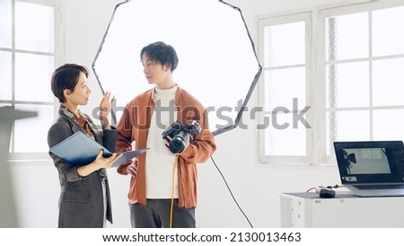 Asian photographer and director talking in the shooting studio.
