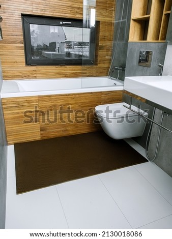 A rubber mat on the floor next to the bathtub in the bathroom. Interior design, modern bath Royalty-Free Stock Photo #2130018086