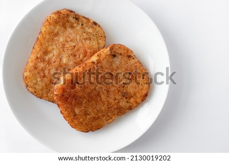 Two Seasoned Hash Browns on a Plate Royalty-Free Stock Photo #2130019202