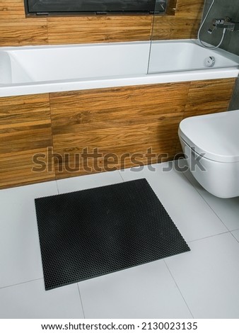 A rubber mat on the floor next to the bathtub in the bathroom. Interior design, modern bath Royalty-Free Stock Photo #2130023135