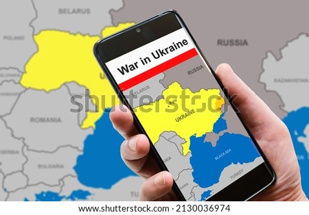 War in Ukraine on mobile phone screen. Ukraine and Russia borders with Donbass on Europe map. Ukrainian-Russian conflict in smartphone. Concept of media, news, refugees, politics and crisis. Royalty-Free Stock Photo #2130036974