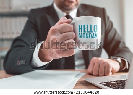 Hello monday coffee cup in hands of a business person during office coffee break, conceptual image with selective focus