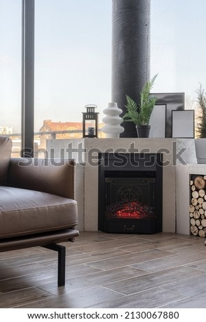 Cropped view of fireplace, decor and sofa in Scandinavian style living room. Modern house with panoramic windows. Spacious flat for sale. Home comfort and coziness concept
