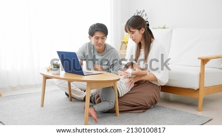 Parents showing their babies their laptops.