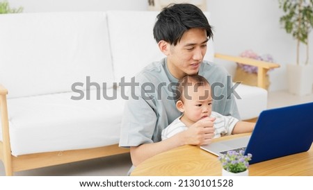 A father showing his baby his laptop.