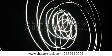 White Neon curved Wave pattern abstract flowing in a isolated black background with copy space made using Light photography technique called Long Exposure. Texture