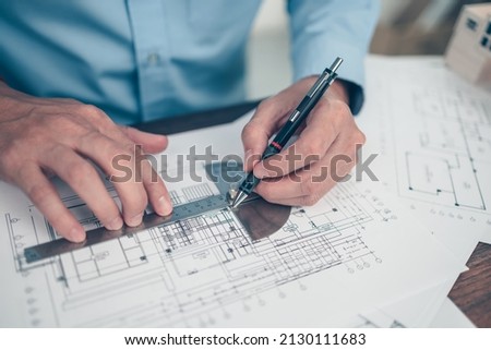 Architect engineer use pen and  angle protector drawing design working on blueprint. House planning design and construction concept.