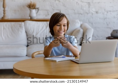 10s boy looking at laptop screen making gestures showing sign language, take part in online class, communicating with tutor using videoconference application with professional speech therapist concept Royalty-Free Stock Photo #2130114947