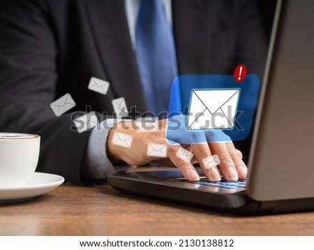A businessman receives a new message with email icons on a virtual screen. Email notification on the laptop. Email marketing concept. Close-up photo
