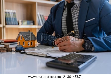 Real estate agents are analyzing insurance discounts. and make home loan decisions for customers to sign real estate purchase contract documents bank employee recommends approval for a mortgage loan