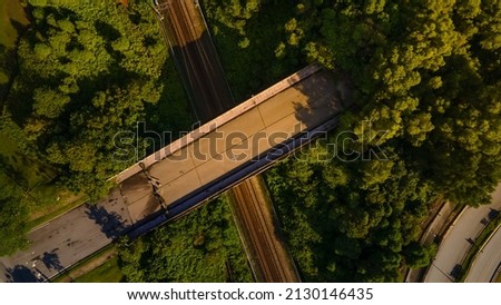 Aerial Drone top down Footage Of  bridge pass over railway track during sunrise Royalty-Free Stock Photo #2130146435